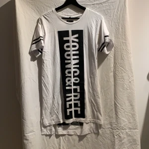 Oversize T-shirt  - Vit unisex oversize T-shirt med texten ”Young and free” på framsidan och ”fearless” på ryggen. Den är inte särkilt bred men är längre. Plagget är i nyskick