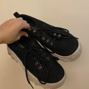 Svarta sneakers  - Ett par svarta sneakers från Nelly strl. 37. Plösen till ena skon har lossnat, därav priset. Kan däremot sys fast lätt. 