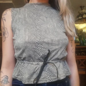 Topp leopard/ormskinnsmönster  - 🦋Topp köpt Second hand i ormskinnsmönster. Knytband av läder där fram. Passar XS-S. Köpare står för frakt. 🦋