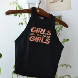  - Tajt topp från London med texten girls need to support girls.