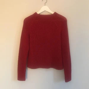  - Röd stickad tröja, sparsamt använd. Den är i L men skulle verkligen säga att det är en S, jag har i vanliga fall M och den sitter tight på mig.  Köparen står för eventuell frakt! 