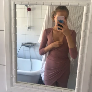  - Supersnygg rosa-beige fodralklänning från Nelly som jag aldrig har använt pga för liten. Längsta delen av klänningen slutar ungefär en dm över knäna och jag är 180cm lång. Fint skick och självklart nytvättad.