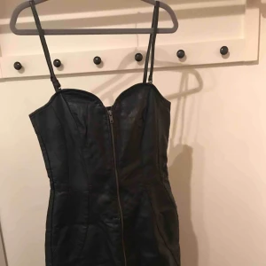  - Läderklänning (mkt inne i höst!!) med dragkedja framtill och snörning i ryggen. I gott skick. 80kr exklusive frakt.