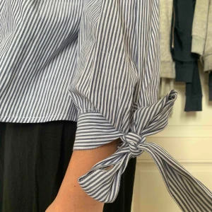  - En somrig blus från amerikan eagle. Off shoulder med knytningar vid armarna.