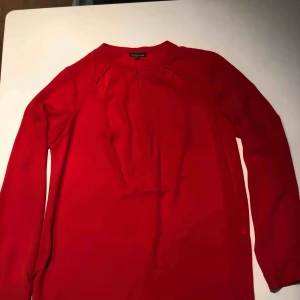  - Röd blus med cutout detalj upptill och dragkedja framtill. Använd ett fåtal gånger och i nyskick. Hämtas i Malmö eller skickas mot frakt. 