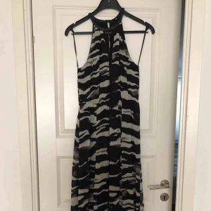  - Svartvit långklänning med slits framtill och elastisk midja. Klänningen är endast använd en gång och är i nyskick.
