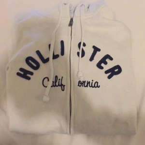  - Säljer min vita hollister hoodie med blått tryck i strl s. Köpt på hollister i gallerian. 