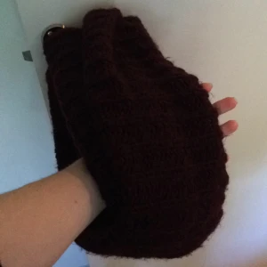  - Mörklila / plommonlila halsduk som viras till två varv. Rund halsduk, inga ändar.