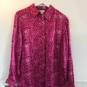 Stor rosa leopardskjorta i glänsande tyg, bra kavlite