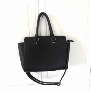  - Fin svart väska men många praktiska fack! Nästan oanvänd så nästan inga slitningar eller liknande. Den har dock en fläck på insidan, se på bild 3, går troligtvis enkelt att tvätta bort! Kan mötas upp i Lund annars står köparen för frakten!💛