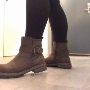  - Ett par bruna vinterkängor med foder. De har dragkedja och ett spänne för utseendets skull. De är väl använda men inte särskilt slitna och fortfarande i bra skick! 