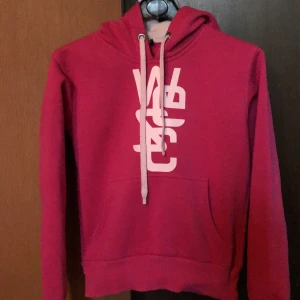 Wesc hoodie  - Skön, använd hoodie i bra skick. Lite sprickor i trycket , se bild 3. Står st l i men jag tycker att den passar s/m mera. Bild 2 ger mer tydligare bild av färgen. Jag har lite svårt att beskriva den. Köpare betalar frakt 