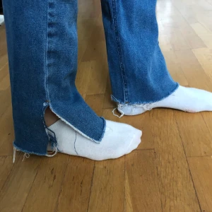 Jeans med slits - Ett par jeans från Nakd med slitningar och slits. Endast använda 2 gånger. Storlek: 36.                150kr eller högsta bud.