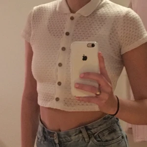 Vit kort croppad skjorta  - En vit kort croppad skjorta med små sydda hål som mönster🥰❤️Bruna träknappar som är fina knäppta men skjortan är även fin öppen! Mycket gitt skick:) Frakt tillkommer☺️