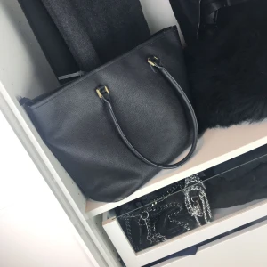  - Stilren och rymlig väska med gulddetaljer, två mindre och ett större fack inuti. 