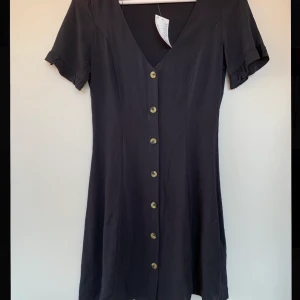 Kortklänning med knappar - Sååå fin klänning med söta knappar, tyvärr för tajt över bröstet på mig😢 Priset är exkl frakt🌷