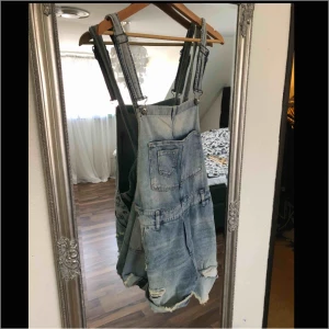  - Jeansshorts med hängslen och slitning. Använd 1 gång. 