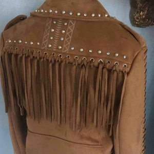  - Oanvänd jacka i mocka imitation med fransar och nitar.