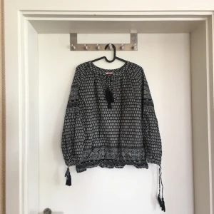 Blus från Indiska - Fin blus med knytning i ärmar och över bröstet, i fint skick.