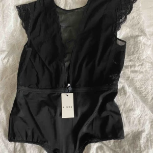  - Snygg spetsbody från pieces Aldrig använd och lapp kvar! Perfekt body till festen.  Nypris 299kr 