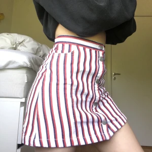 Söt kjol från Monki - Söt kjol från Monki med ett rött och mörkblått randigt mönster, knapparna går att knäppa upp hela vägen. Endast använd en gång, perfekt nu inför sommaren :) frakt: 44 kr