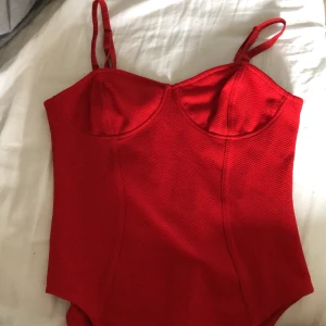 Röd body  - En supergullig röd body! Knappt använd, och bra kvalite. Frakt tillkommer om man inte kan mötas upp i Gävle 