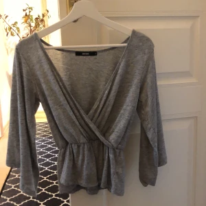 Grå blus med urringning från Bik Bok - Använd fåtal gånger, köparen står för frakt