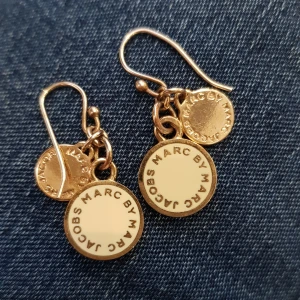 Marc by Marc Jacobs - Otroligt fina och lyxiga örhängen ifrån Marc by Marc Jacobs. Guld med vit bakgrund. Äkta