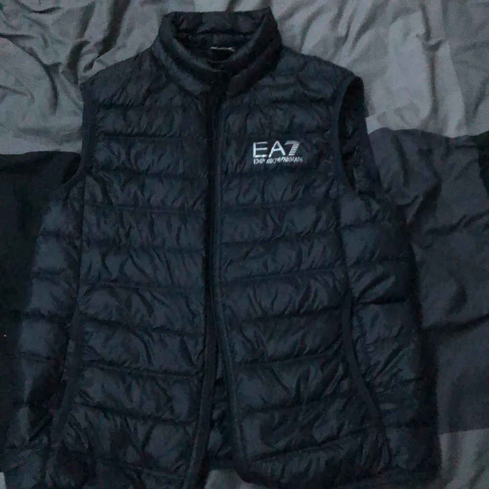 Selling my EA7 Emporio Armani vest because I stopped using it and I want to try to make some money back on a good bargain! | Retail 1600kr | Some small holes just below the left pocket but that aren’t visible and no fluff gets out!. Jackor.