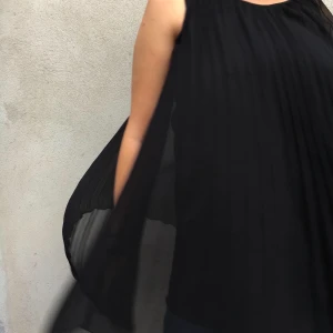 Svart typ pressvikt klänning.  - Sjukt flowy klänning/linne. Pressveckat tyg som är lite genomskinligt. Men med underklänning fastsydd under. Jag älskar att ha den som klänning men är för lång för det. Frakt tillkommer (kolla gärna in resten av mina kläder så går de på samma frakt) Jkpg