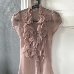 Blus - Gammelrosa blus med volanger över bröstet. Från Saint Tropez storlek XS