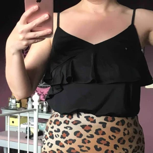  - Svart volangtopp, aldrig använd. Reglerbara axelband och lite stretch.   Betala med swish! Frakten är 45 kr. Samfraktar om du köper fler kläder av mig.