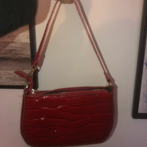 Väska - Röd liten väska som inte kommer till någon användning längre. 