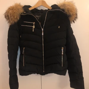 Hollies Jacka  - Supersnygg dunjacka från Hollies med en stor och härlig pälskrage av äkta päls. Storlek 38, använd sparsamt 💗💜💗 Orginal pris: 3500kr 