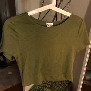 Grön croptop - En mossgrön croptopp från hm i storlek M. Lite nopprig men annars i fint skick. Frakt tillkommer