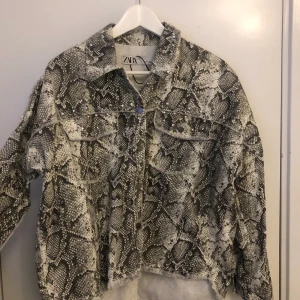 ZARA JACKA MED MOTIV OCH NITAR - En trendig och unik snakeprint jacka från Zara. Finns ej kvar i butik. Knappt använd. Frakt: postens blå påse (M) 59kr så 259 inklusive frakt om inte uppmötes i Gävle