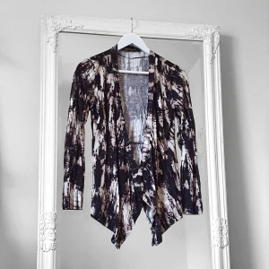 Alice Bizous kofta XS Joy - Färg: svart/beige/vit.  Strl: XS.  Fin kofta från Joy, av märket Alice Bizous.  Figursydd, ingen knäppning. Fint fall, längre fram. Använd vid ett tillfälle endast, så gott som ny! (Nypris: 699 kr) Kommer ej till användning & stor garderobsrensning pågår!