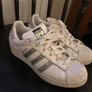 Adidas superstar strl 38 - Snygga  adidas sneakers med silverglitter ränder. Använd fåtal gånger så i gott skick. Strl 38