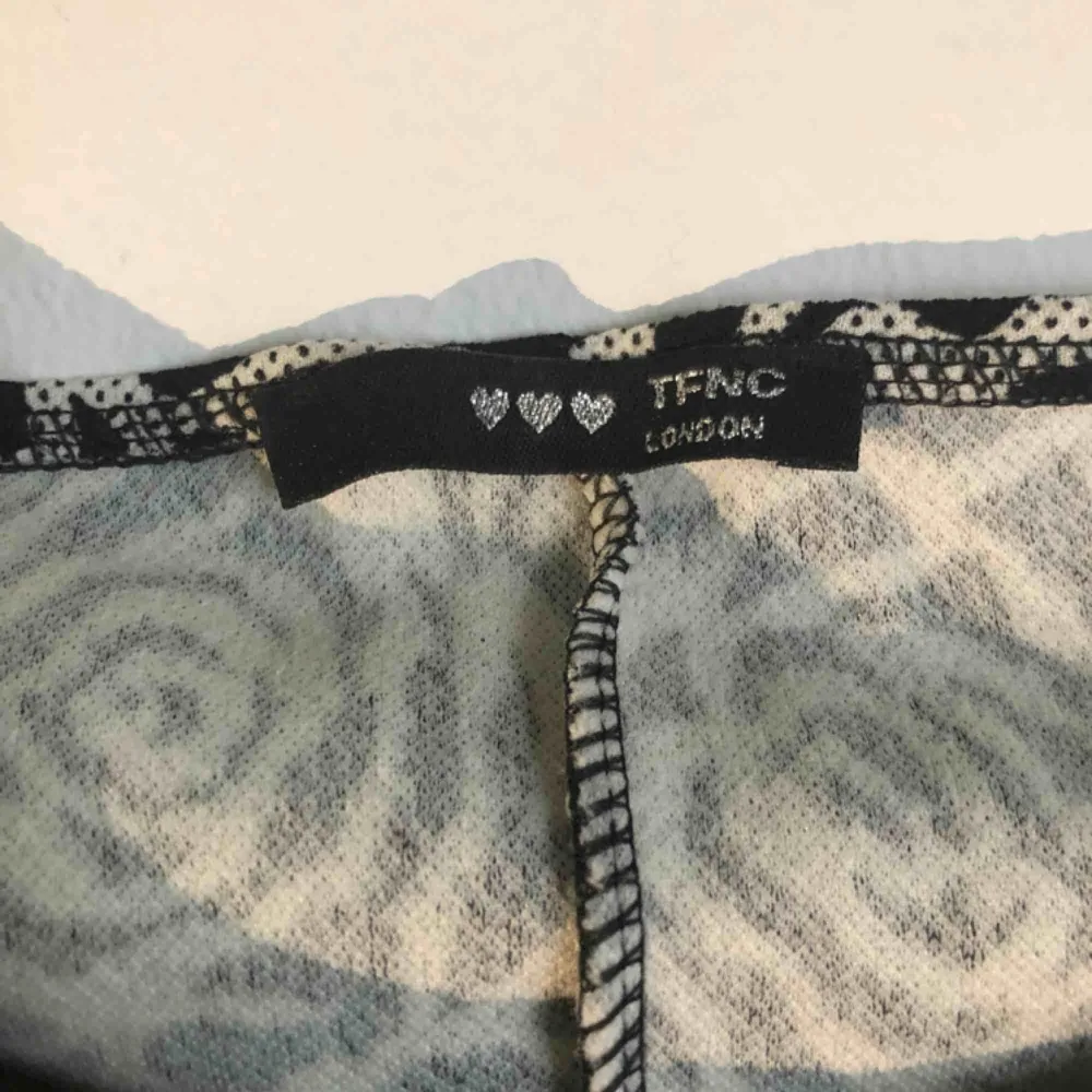 Figursydd, skön och stretchig klänning från TFNC i London. Använd en gång! Inköpt 2016, London för 1299kr. Vackert svart/vitt/grått rosmönster från vinterns supertrend, blommigt. . Klänningar.