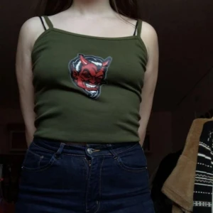  - Säljer grönt linne med en röd djävul på. Aldrig använt. 