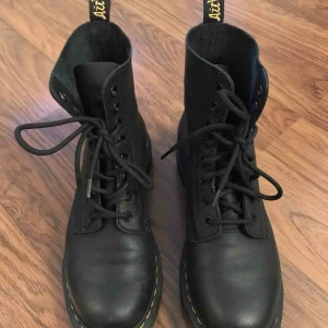  - Dr Martens Pascal 1460 svarta i skinn. Väldigt sparsamt använda kängor i mjukt skinn med snörning, storlek 39. I superfint skick! Ordinarie pris 1700kr. Skickas med postnord. 
