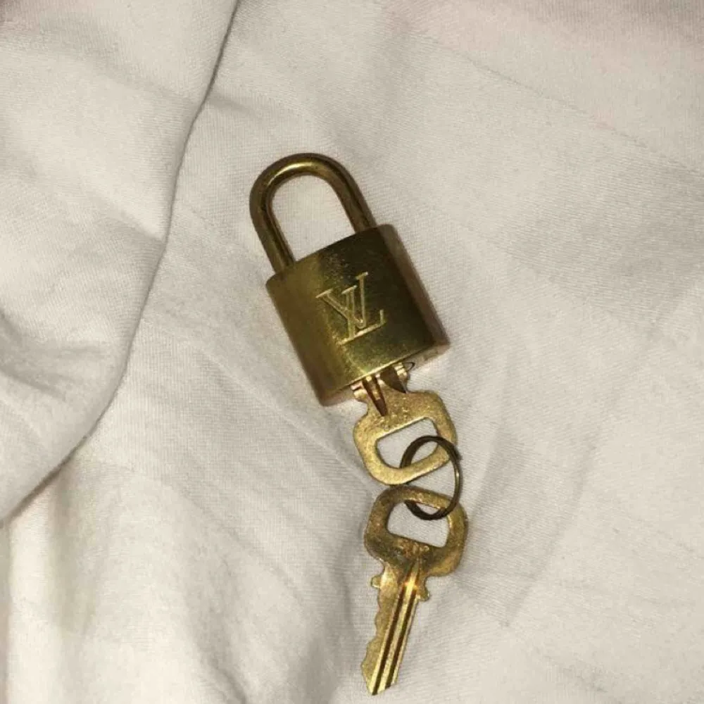 Säljer ett äkta padlock från Louis vuitton. Står nummer 302. Ingår 2 stycken nycklar till. Man kan använda låset till sin Louis vuitton väska eller använda det som ett halsband👌🏽. Accessoarer.