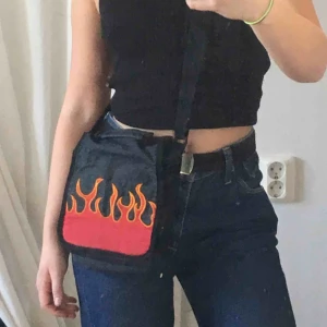  - Skitsnygg väska med flammor på. Innehåller flera fack. Köparen står för frakt🥰🥰