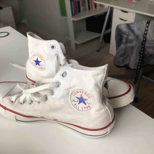  - Vita, höga converse. Använda för ett tag sen men orörda sedan länge. 