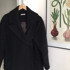  - Jättefin ullkappa (45%) från Åhléns egna märke Wera Stockholm. Grymt bra skick!  Jättemysig även i vinter.  Man får lätt plats med tjockare tröja under.  Den är oversized i modellen och passar dig som har strl 34-36. Jag är 160 lång och på mig slutar den vid knäna. Nypris runt 1000kr 