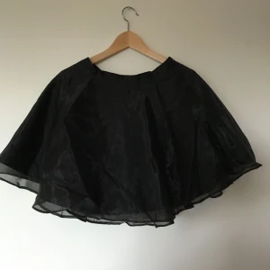  - Klockad minikjol i svart organza från HM. Ej använd. Om den postas tillkommer frakt 