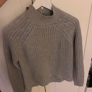  - Gråstickad turtleneck tröja, köparen står för frakten
