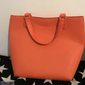 En jättefin orange handväska som är använd sparsamt
