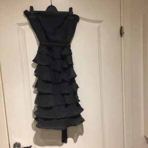  - Volangklänning från Only. Snygg passform, har en mörkgrå/blå färg. Passar strl M.