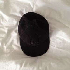 En ball svart keps, ganska stor - En ball svart keps, ganska stor